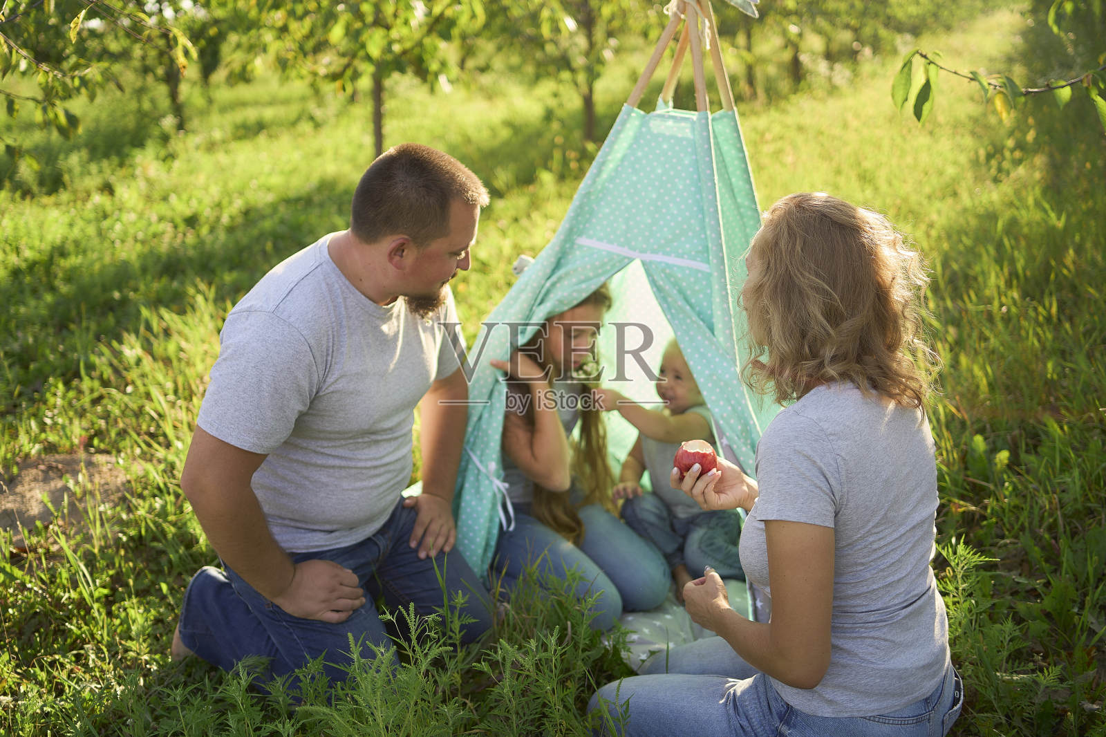 一家人带着蹒跚学步的孩子在花园的棚屋里玩耍照片摄影图片