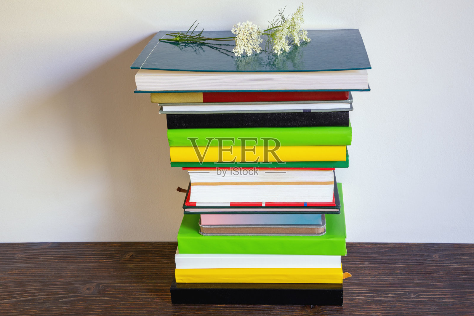 在质朴的桌子上堆放着五颜六色的书。本空间照片摄影图片