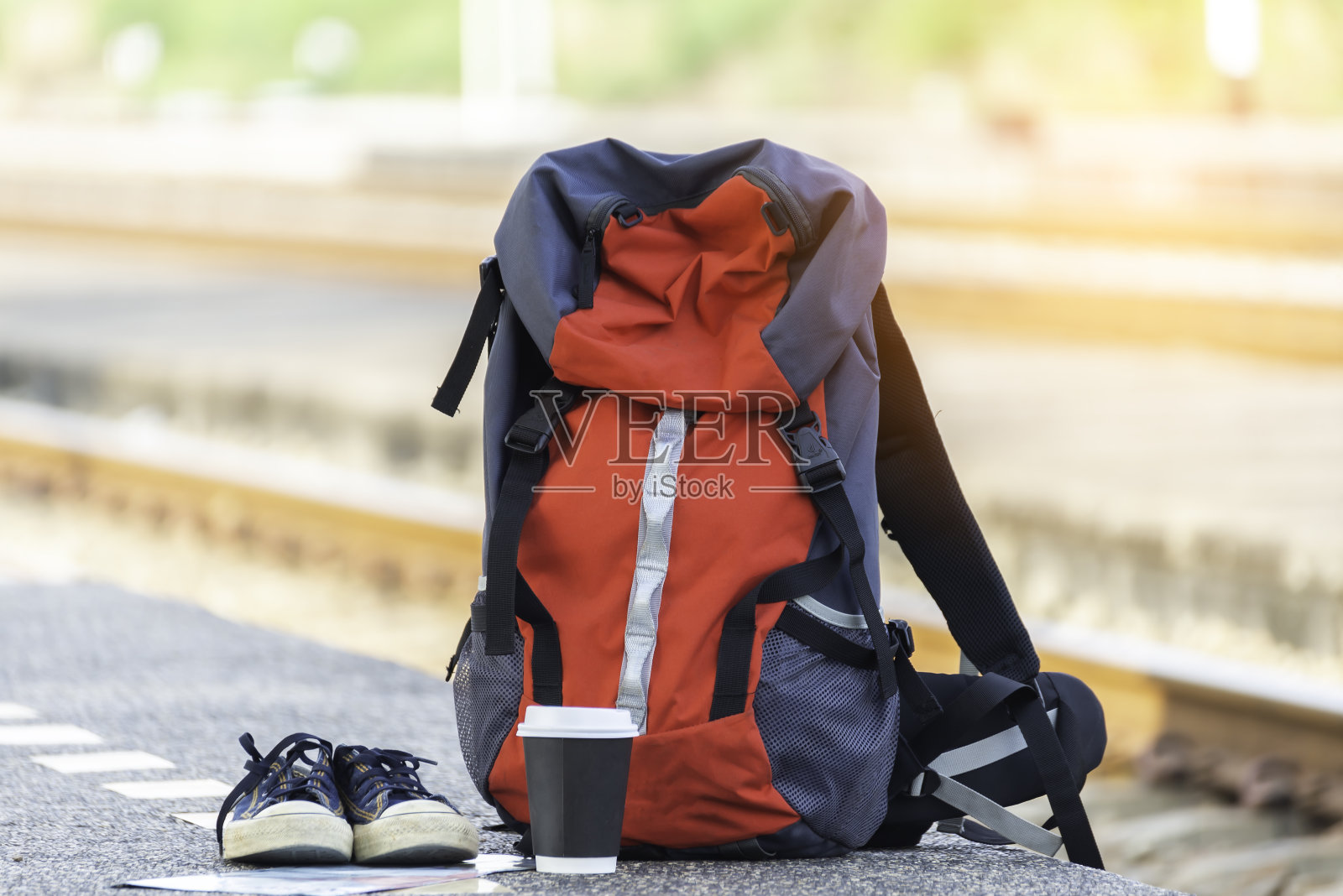 旅行者和亚洲旅游的年轻女子背着背包，拿着地图，在等火车。旅行的概念。照片摄影图片