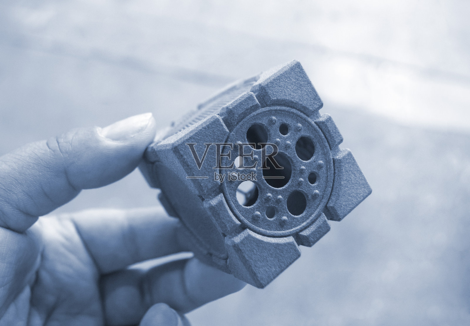 一个人手里拿着3D打印机打印出来的物体。打印几何模型照片摄影图片
