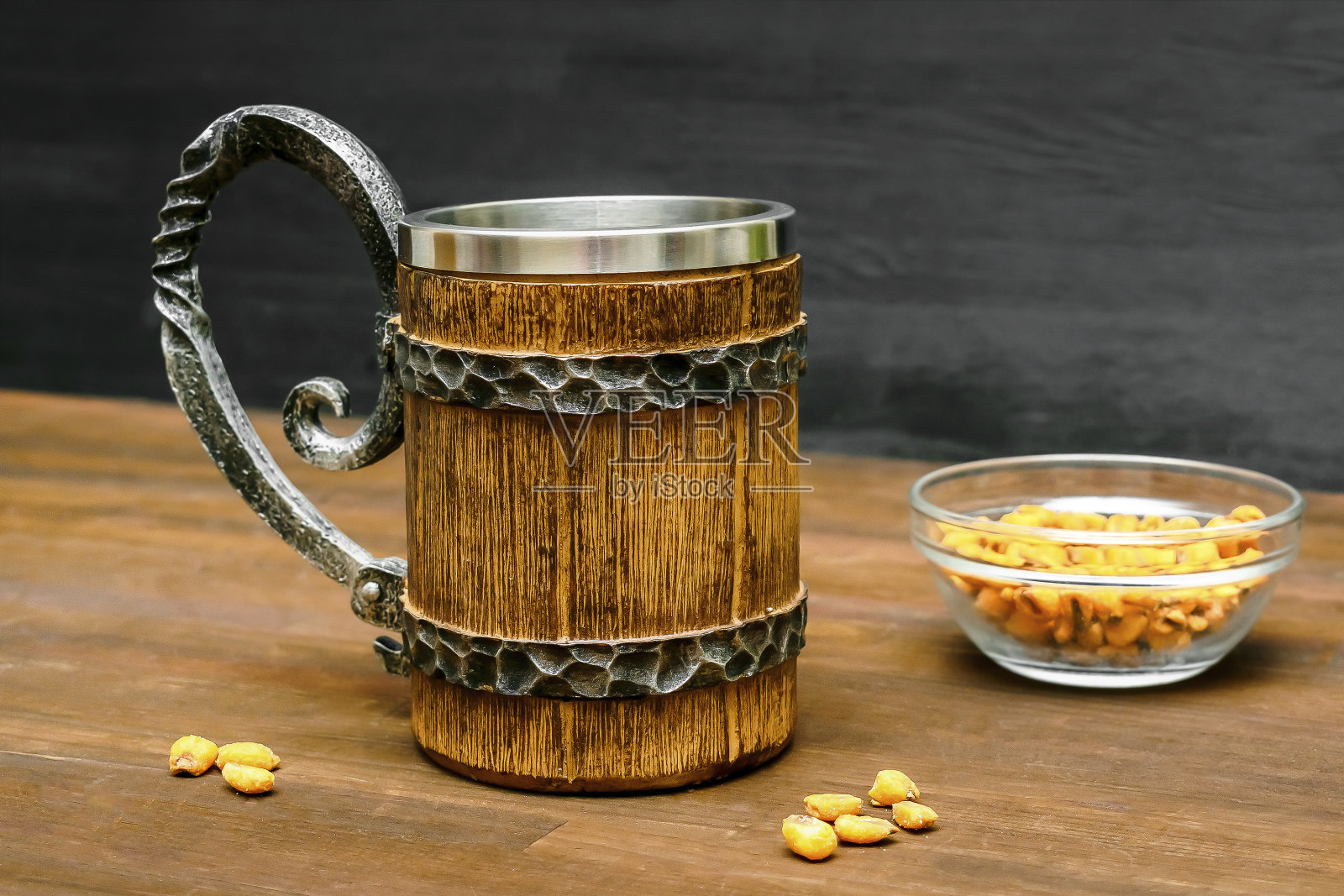 棕色的大杯子里装着啤酒、麦芽酒和脆脆的零食、椒盐脆饼、玉米、坚果，放在木桌上的碗里，背景特写。酒精鸡尾酒，酒吧饮品，豪饮派对概念。模型，模板，复制空间照片摄影图片