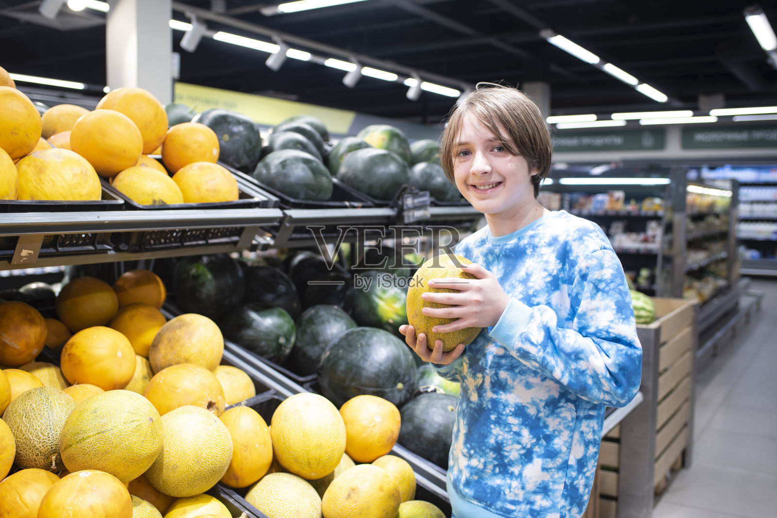 一个微笑的男孩在超市里挑选西瓜照片摄影图片