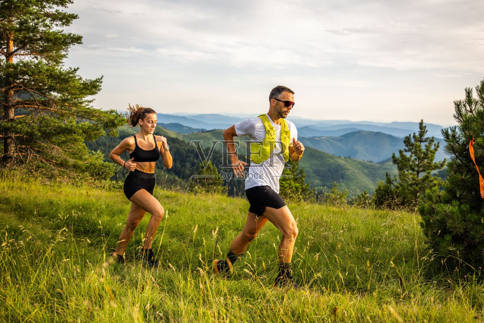 清晨，一对高加索夫妇在绿意盎然的山间小道上跑步照片摄影图片