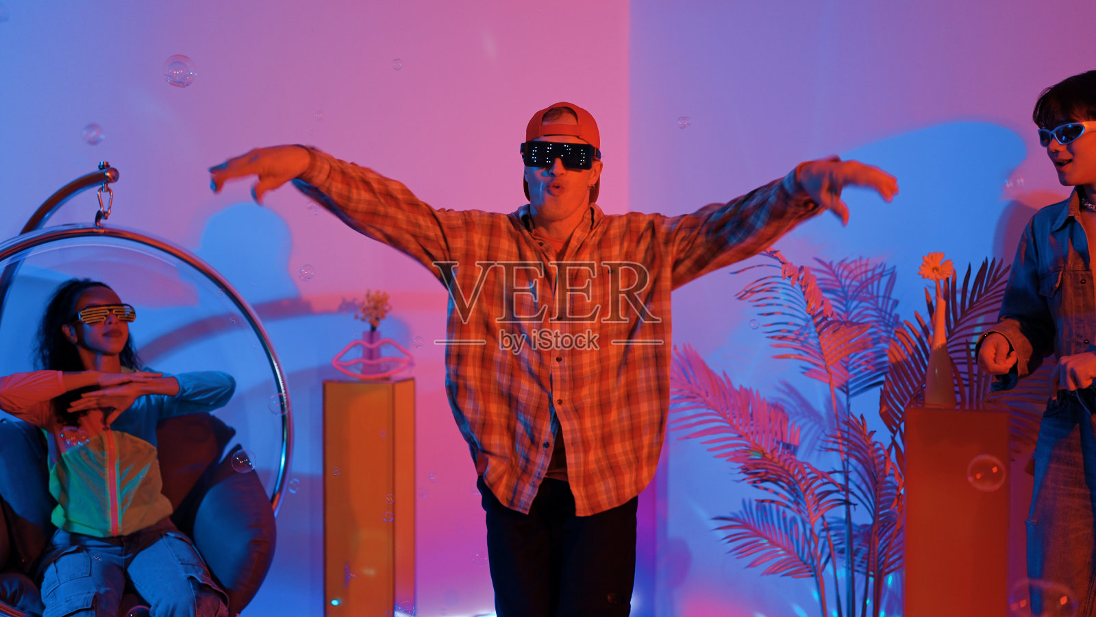 快乐的嬉皮士表演霹雳舞，而朋友在演播室欢呼。盛宴。照片摄影图片