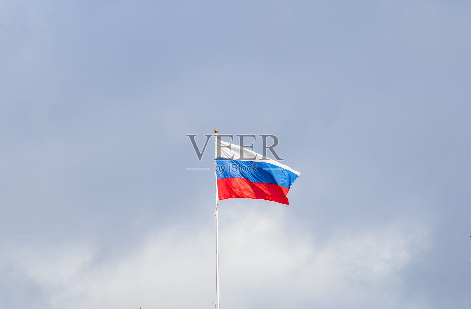 迎风飘扬的俄罗斯三色旗映衬着蓝天。照片摄影图片