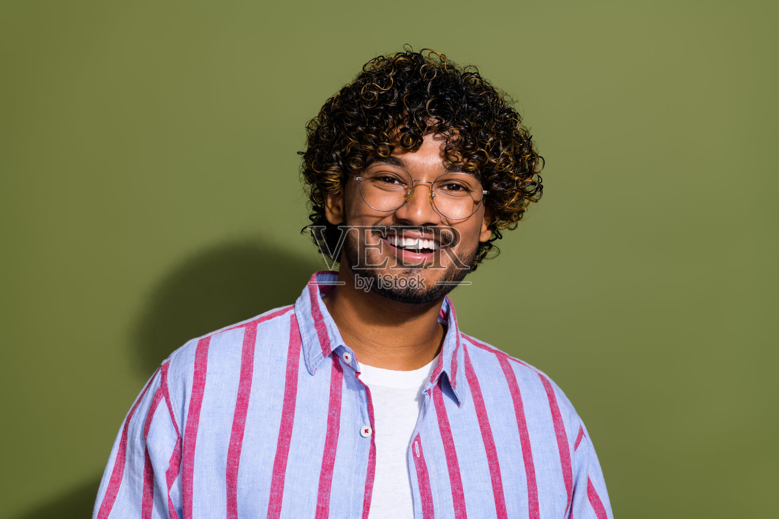 肖像照片微笑快乐聪明英俊的阿拉伯商人在条纹休闲衬衫和眼镜孤立的卡其色背景照片摄影图片