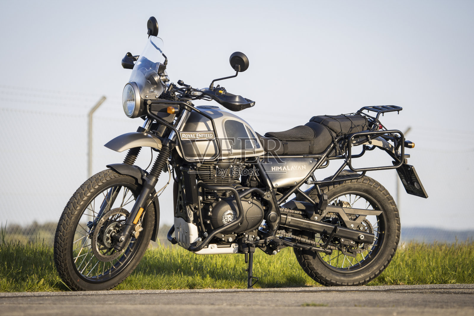 经典的皇家恩菲尔德喜马拉雅越野摩托车停在傍晚的阳光照片摄影图片