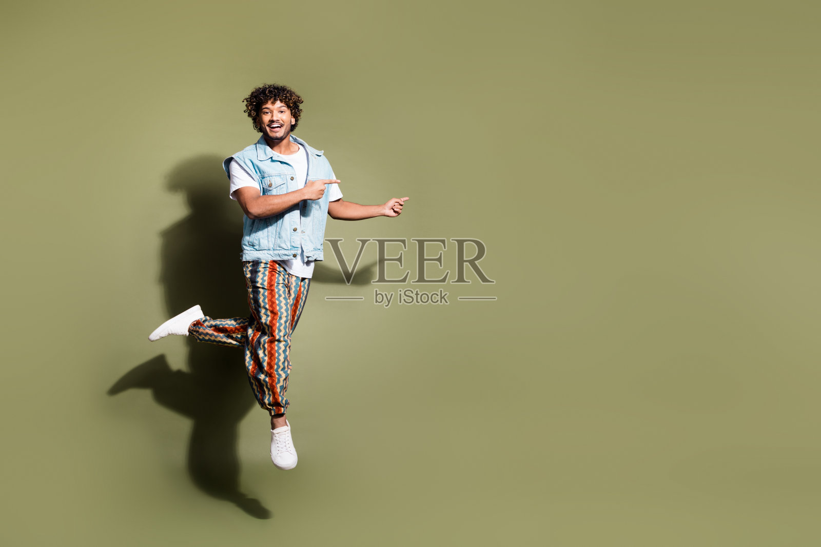 全尺寸照片英俊的年轻人跳点空穿时髦的牛仔裤装孤立的卡其色背景照片摄影图片