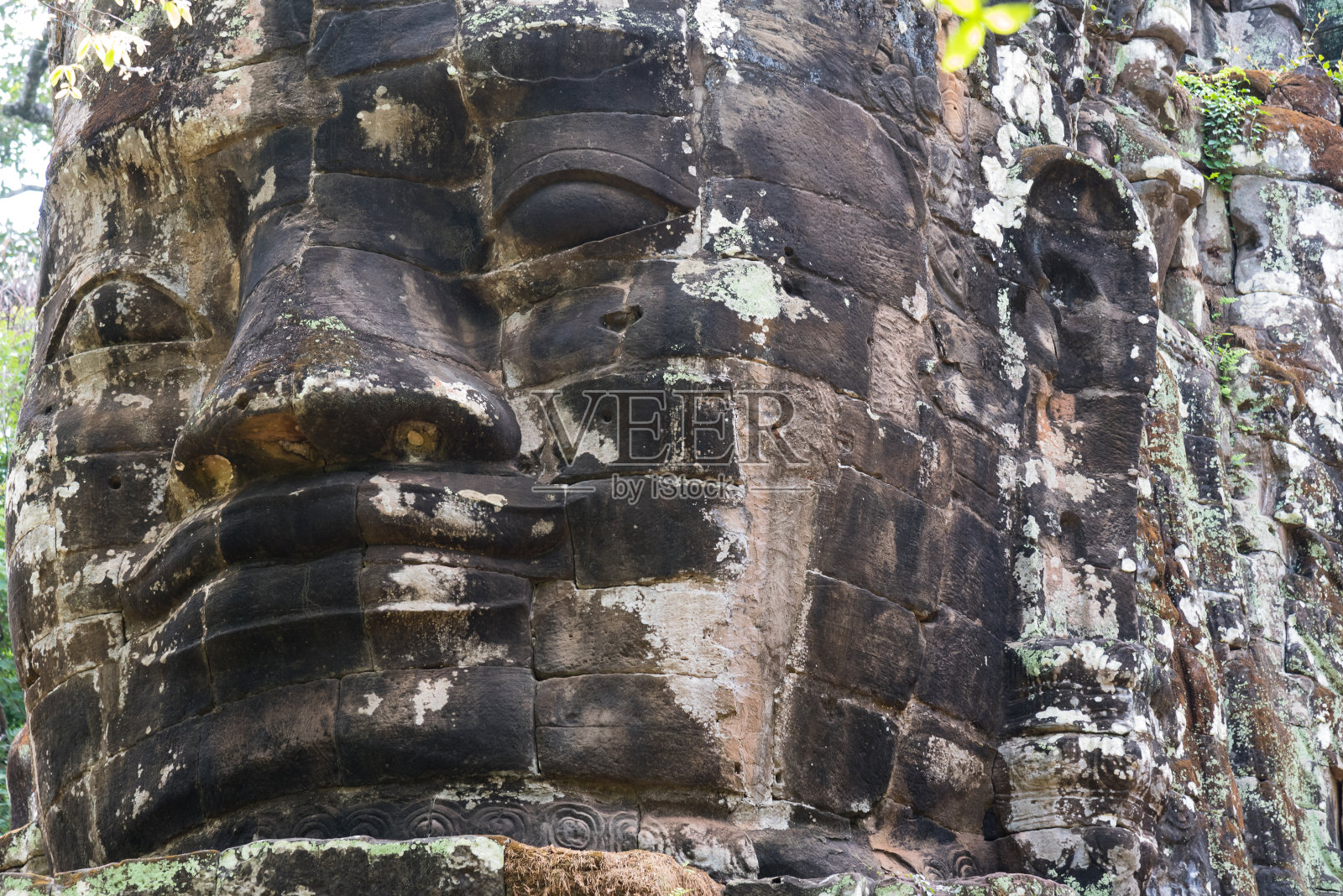 在柬埔寨暹粒的吴哥窟历史悠久的寺庙建筑群中，巨大的头部雕塑特写照片摄影图片