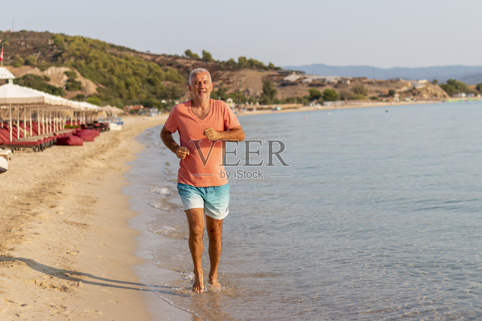 一个有着积极生活方式的成熟男人在海边奔跑照片摄影图片