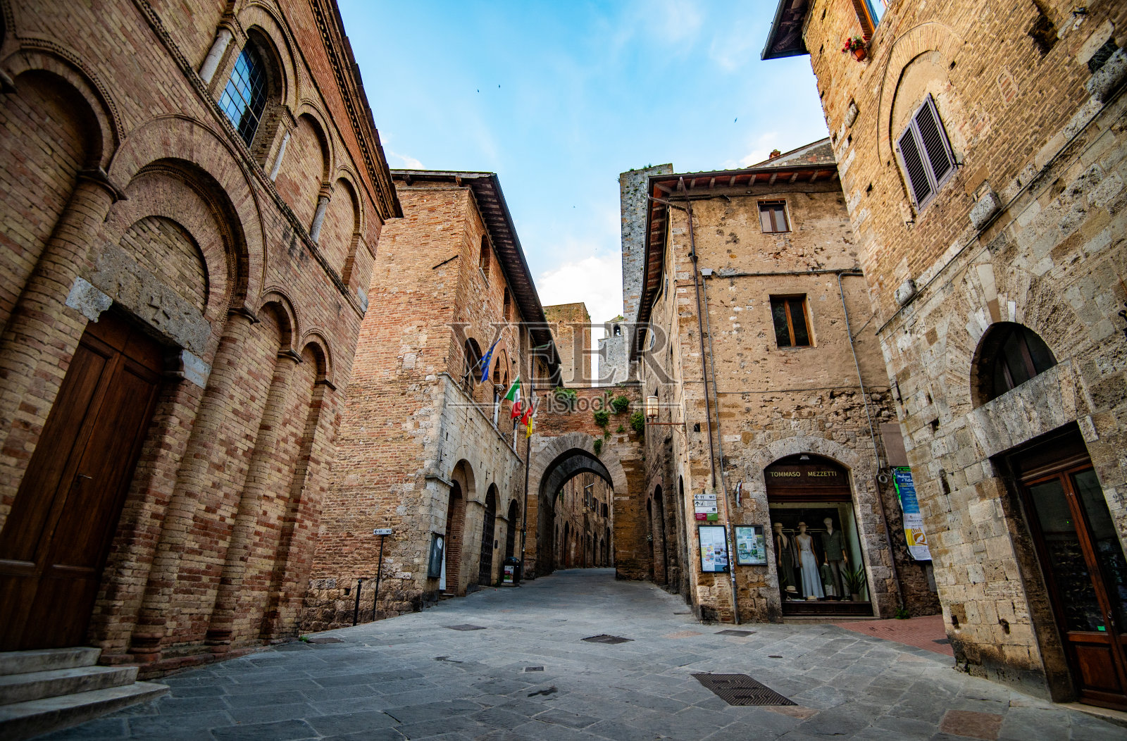 圣吉米尼亚诺，意大利，2024年5月25日:古老的街道两旁是石头建筑和宫殿照片摄影图片