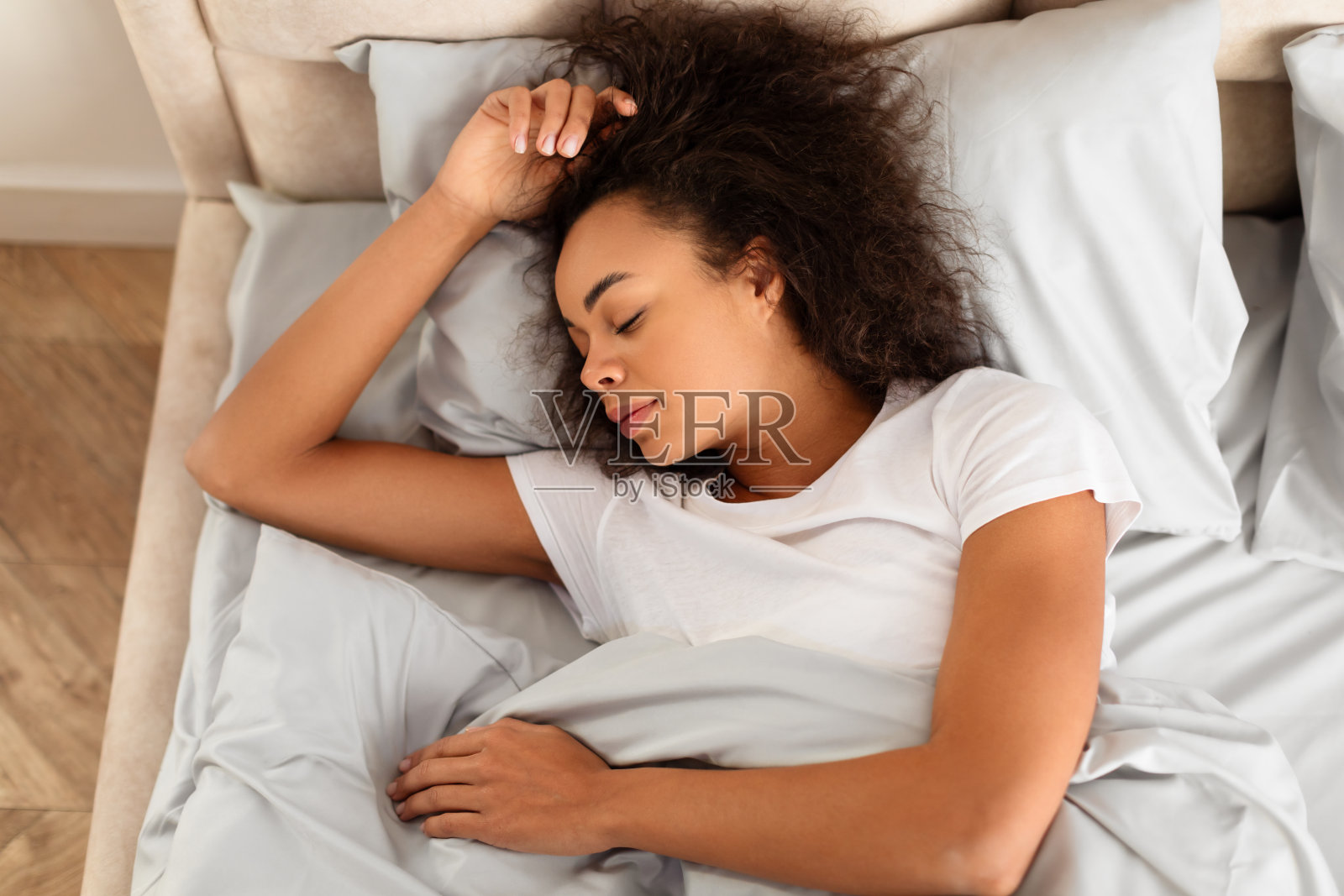 年轻黑人女性在现代卧室里睡觉的俯视图照片摄影图片