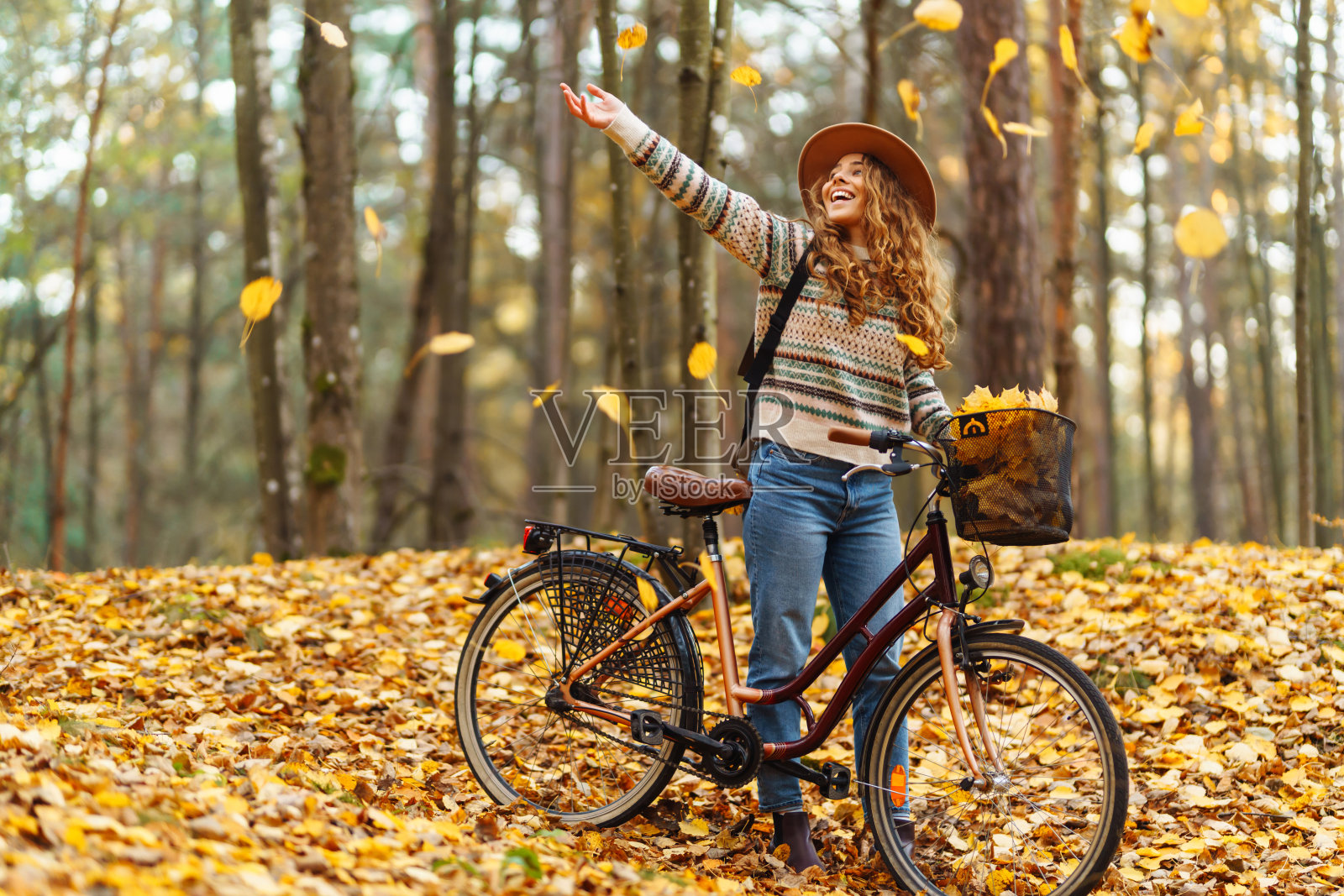 在金秋公园骑自行车的快乐女游客。照片摄影图片