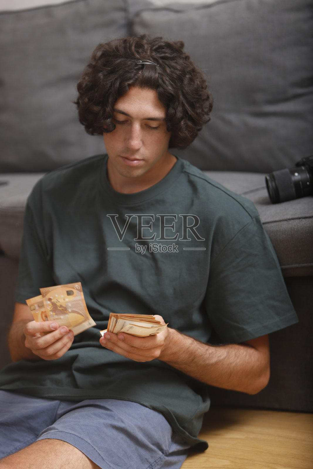 小男孩微笑着从存款中数出50欧元的钞票照片摄影图片