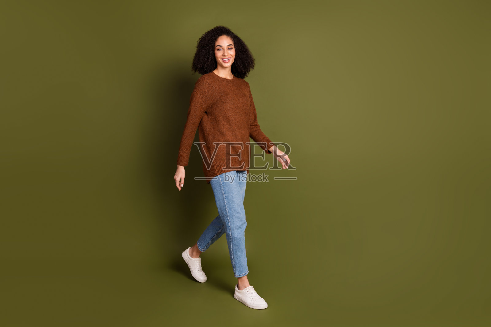 完整的肖像漂亮的年轻女子走空空间穿毛衣孤立的卡其色背景照片摄影图片