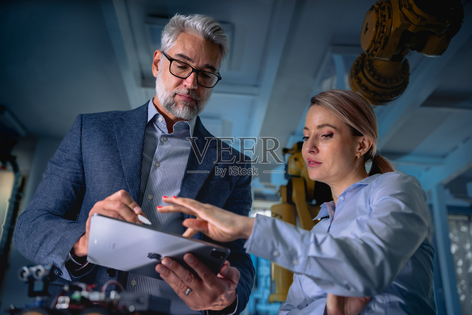 两个机器人工程师站在实验室里研究新项目。现代工业技术的概念，自动化流程，汽车照片摄影图片