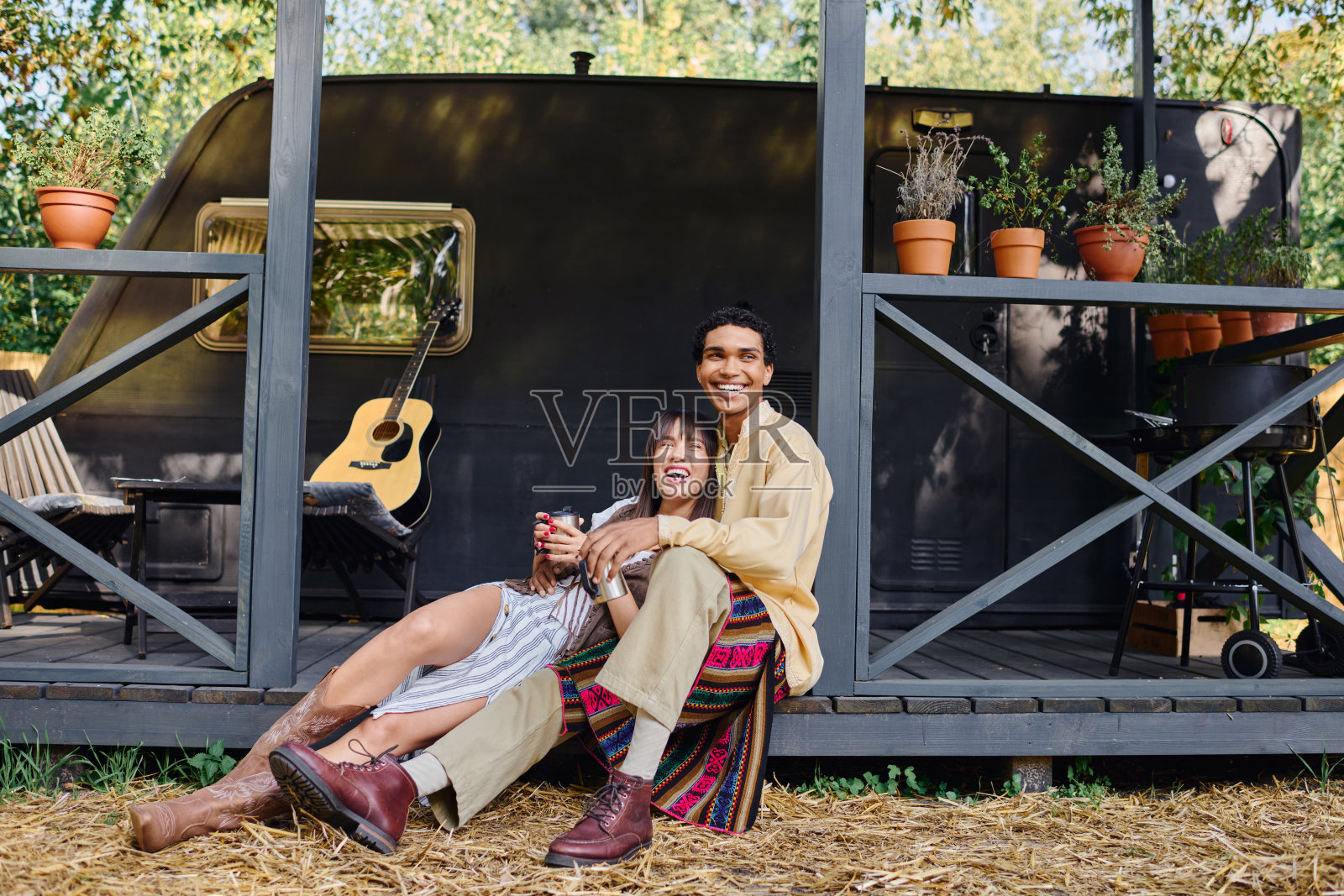 在郁郁葱葱的森林里，年轻的多元文化夫妇在他们的露营车附近享受快乐的时刻照片摄影图片