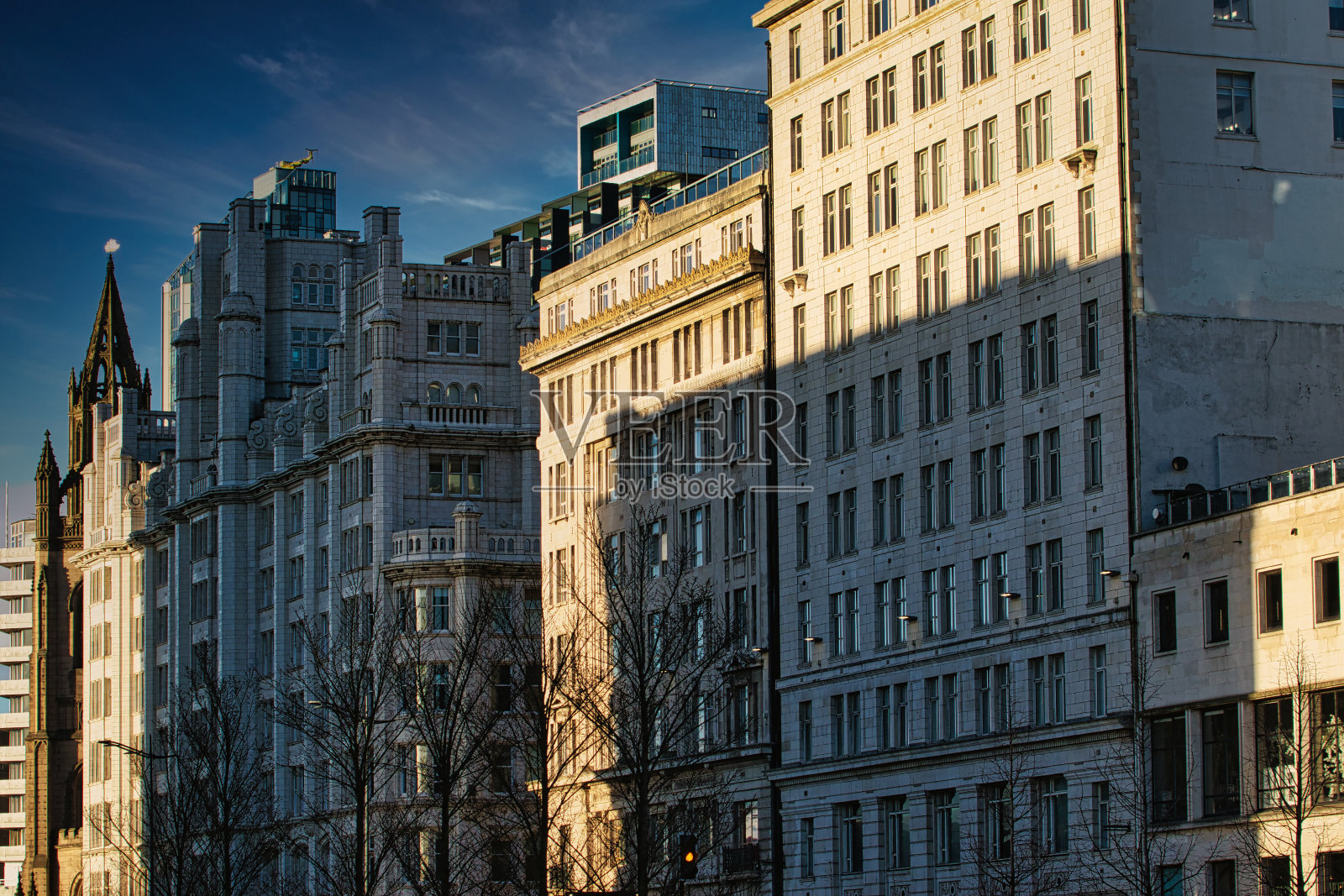 英国利物浦的城市天际线，现代建筑沐浴在金色的阳光下，湛蓝的天空。照片摄影图片
