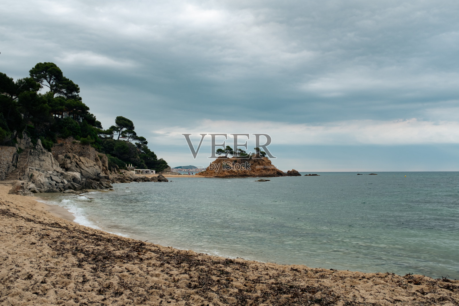 美丽的沙滩在宁静的地中海海岸布拉瓦海岸，加泰罗尼亚在暴风雨多云的天空下照片摄影图片