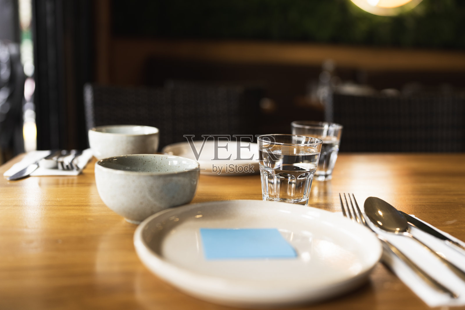 精致的餐桌布置，盘子上有一张蓝色的便利贴照片摄影图片