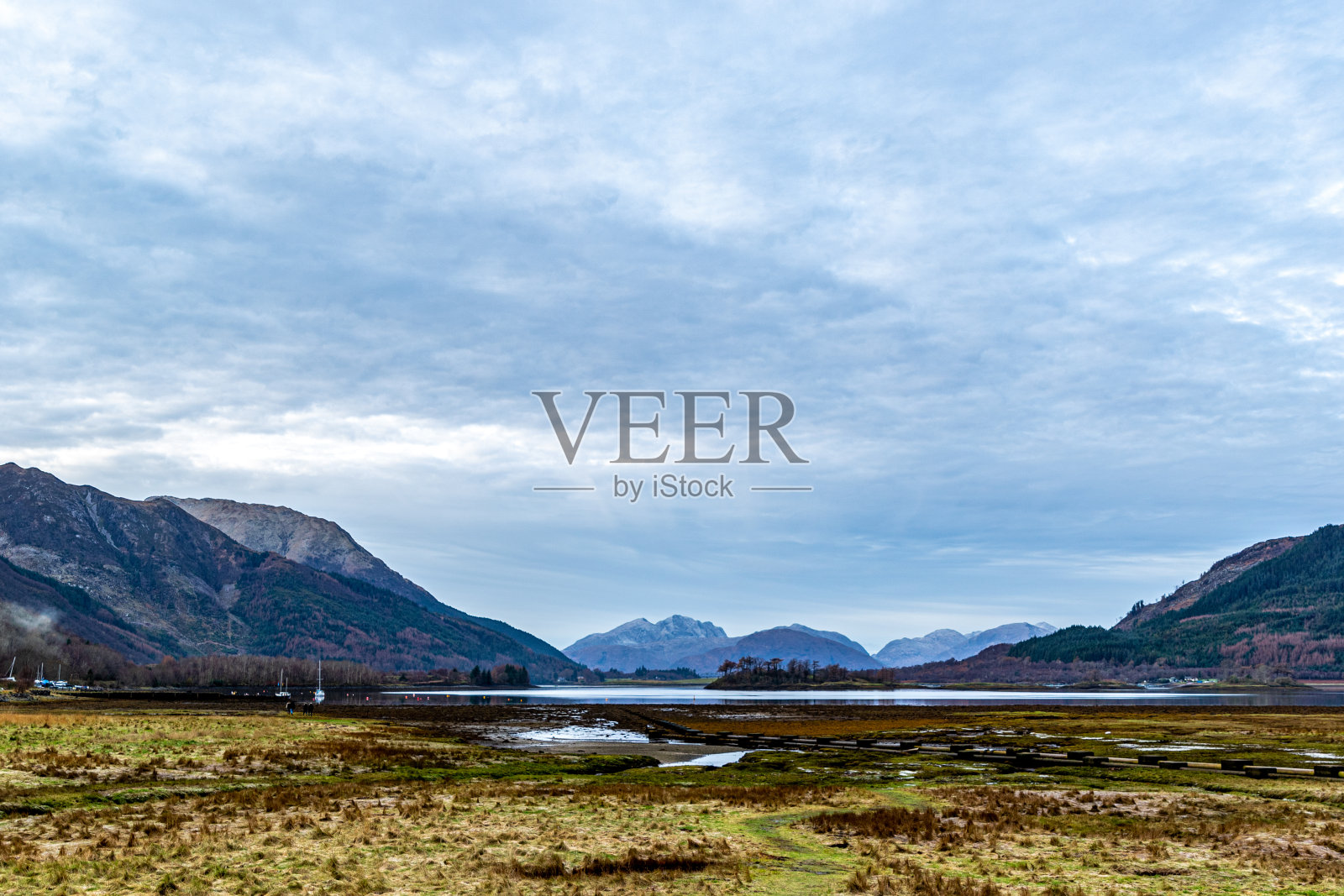 宁静的山谷景观与山，一条河，和阴天。照片摄影图片