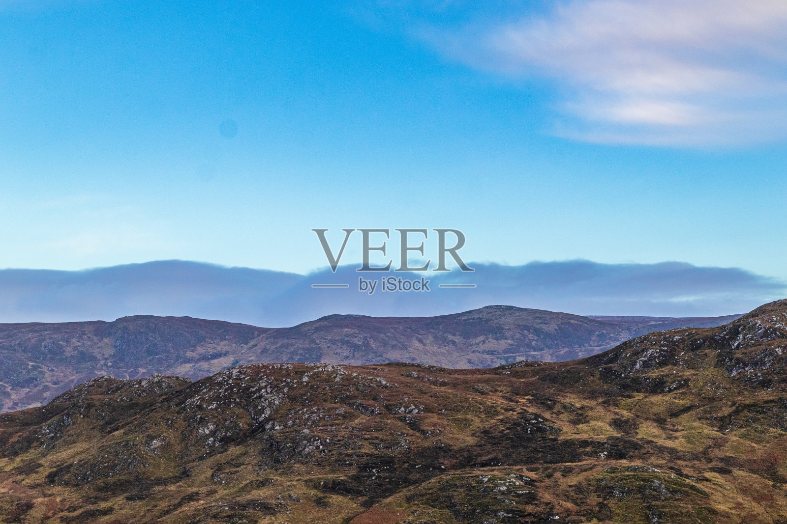 湛蓝的天空下连绵起伏的群山，远处飘着轻柔的薄雾。照片摄影图片