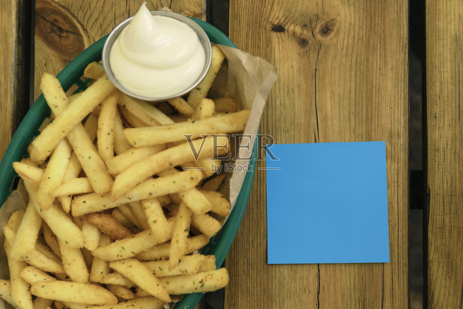 在户外的桌子上放着薯条，上面写着空白的蓝色音符照片摄影图片