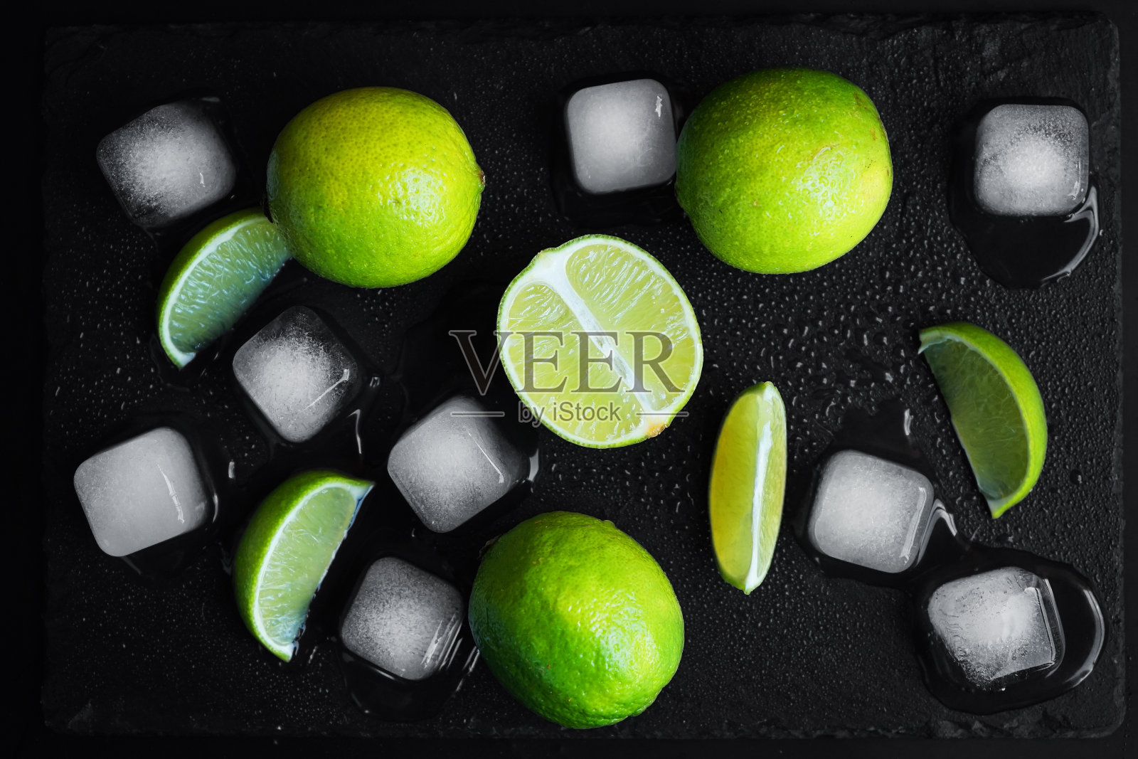 切成片和整片的酸橙放在冰块旁边照片摄影图片