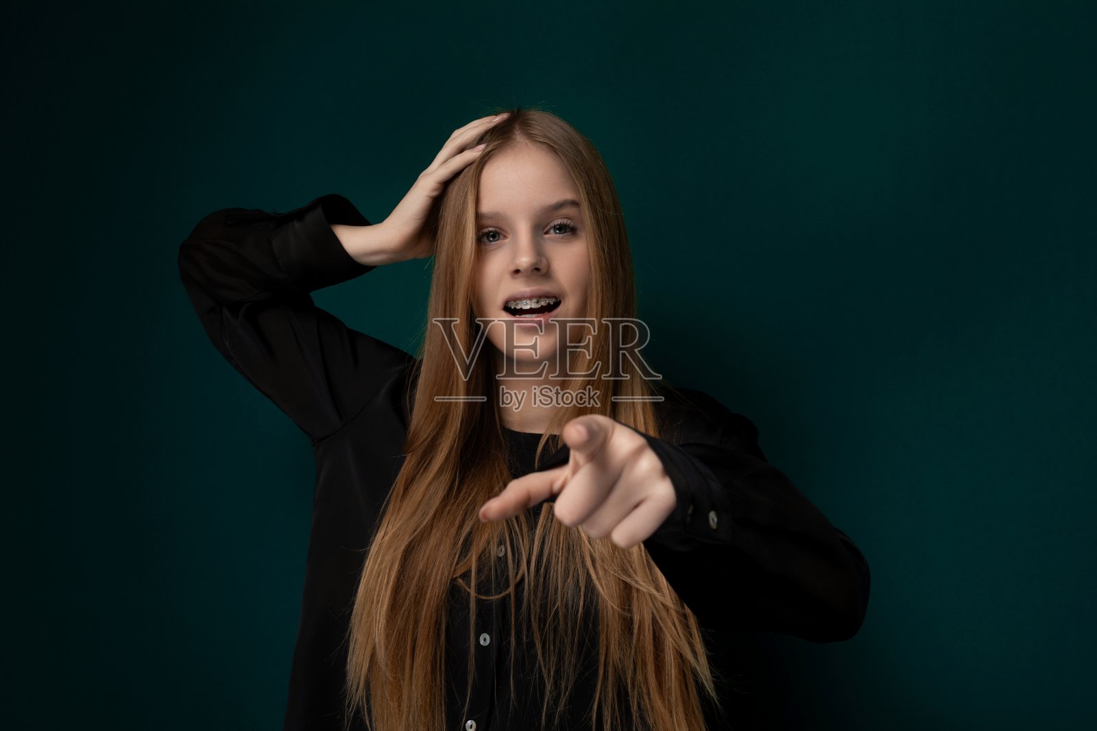 一头红长发的女人指着镜头照片摄影图片