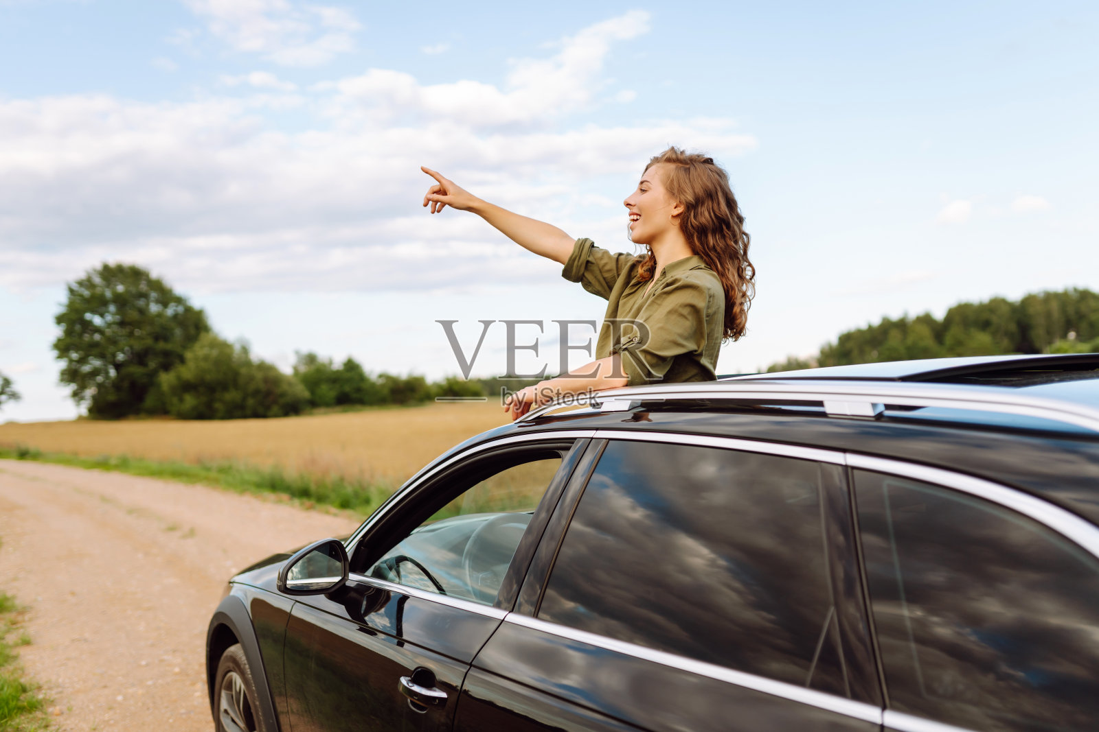 美丽的女人享受大自然，看着窗外的汽车，而有一个公路旅行。照片摄影图片