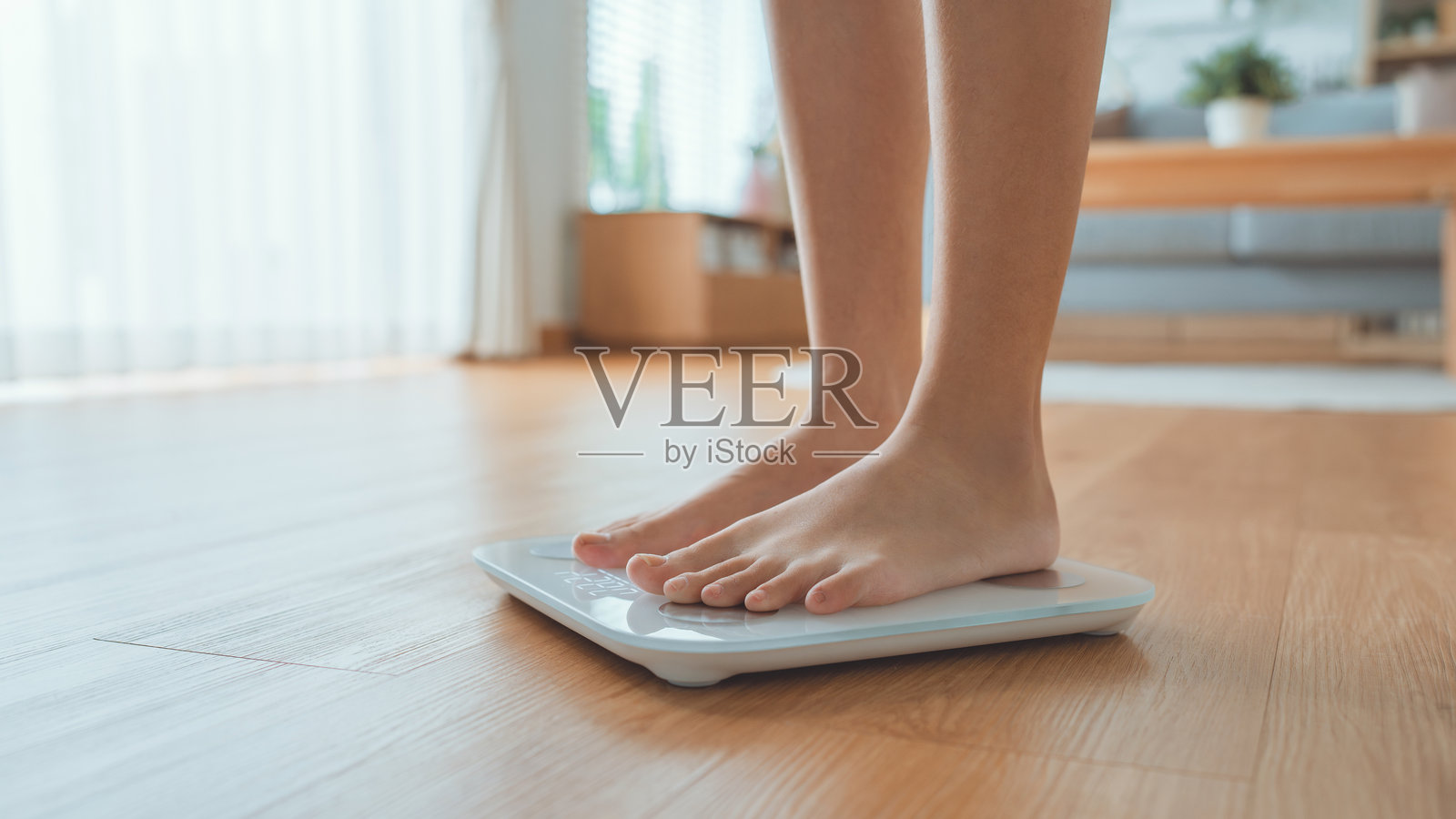 女性双脚站立称体重，女性检查体重指数减肥。赤脚测量身体脂肪超重照片摄影图片