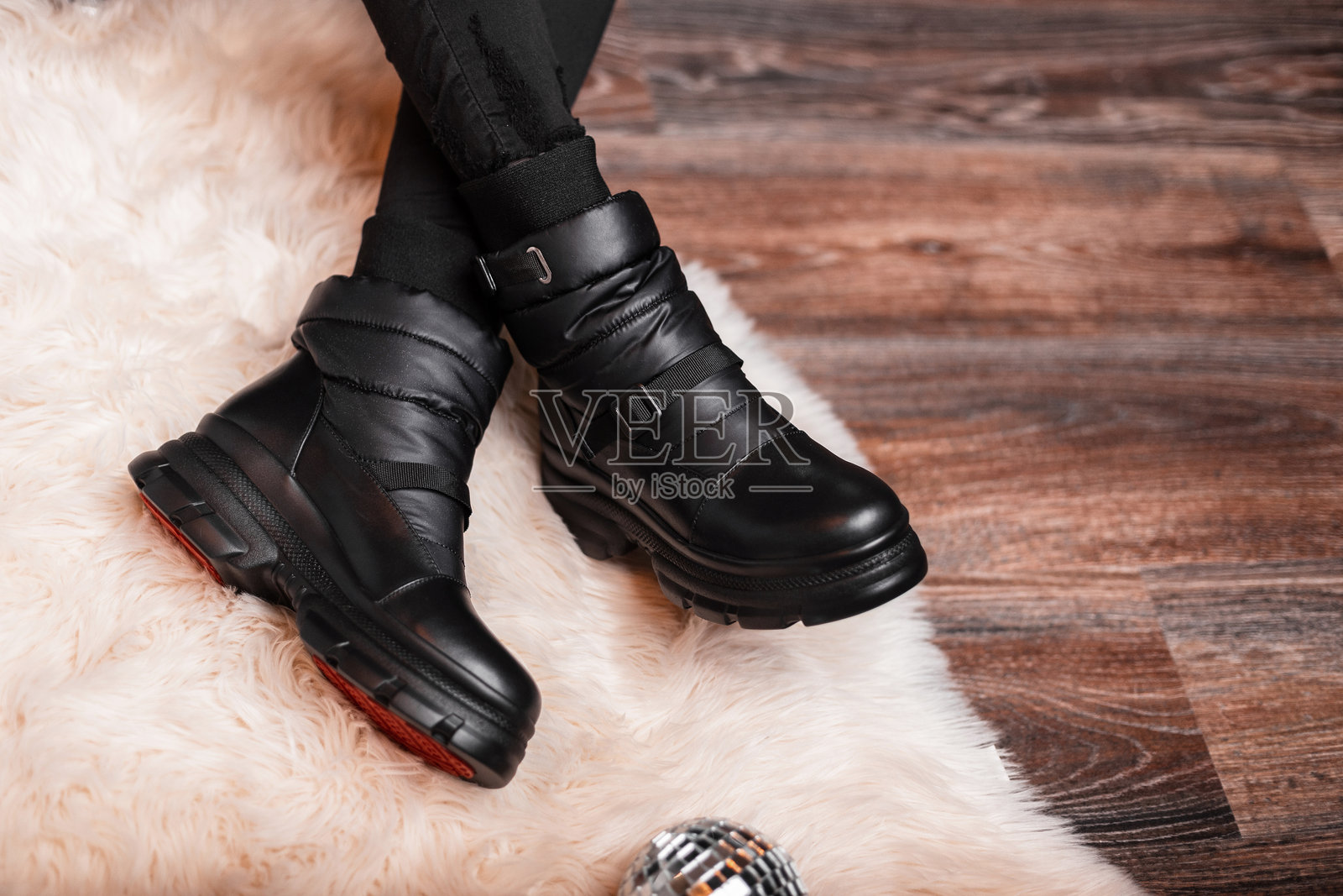 女性腿上的时尚女性黑色保暖冬季靴子。特写镜头。青春时尚秋冬系列真皮保暖鞋。照片摄影图片