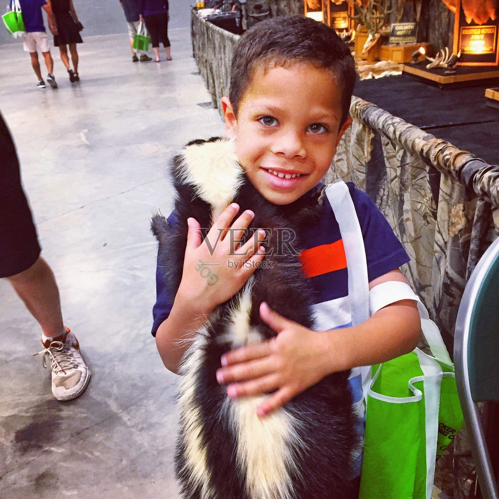 小男孩抱着臭鼬在购物中心的画像照片摄影图片