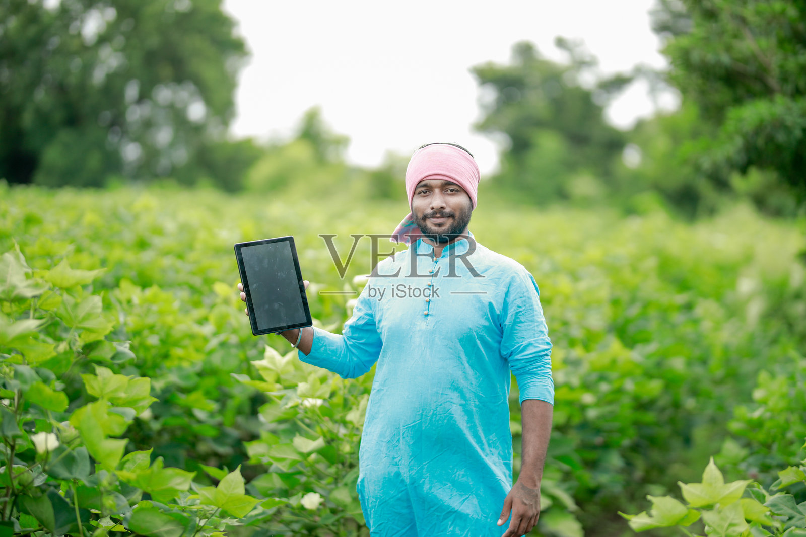 快乐的年轻印度农民使用智能手机照片摄影图片