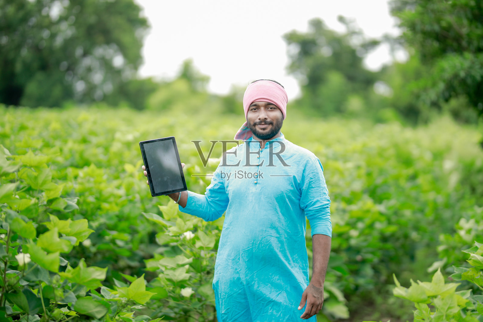 快乐的年轻印度农民使用智能手机照片摄影图片