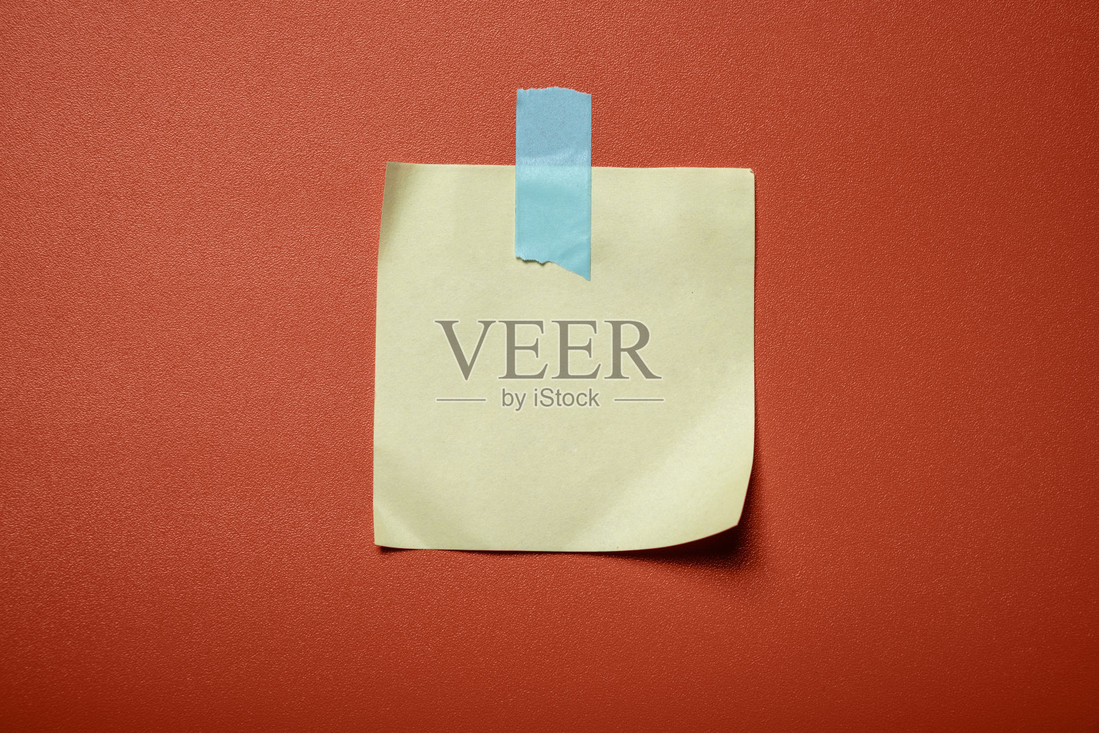 一张黄蓝相间的便签贴在红色的背景上照片摄影图片