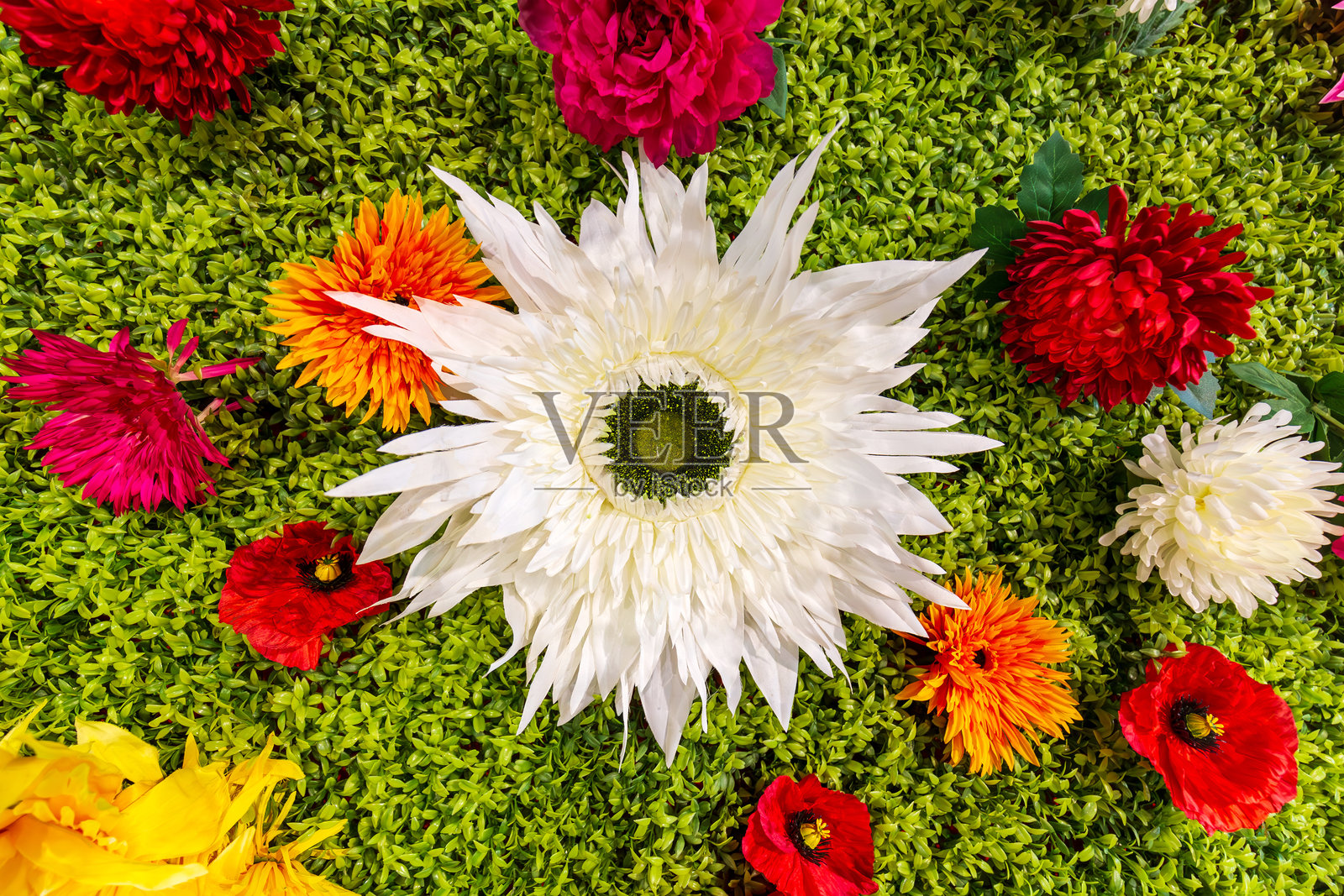 绿植墙上五颜六色的人造花插花照片摄影图片