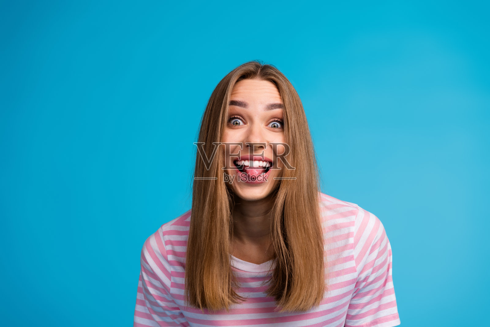 照片肖像的快乐快乐有趣的女人穿着时尚的条纹粉红色的衣服孤立的蓝色背景照片摄影图片