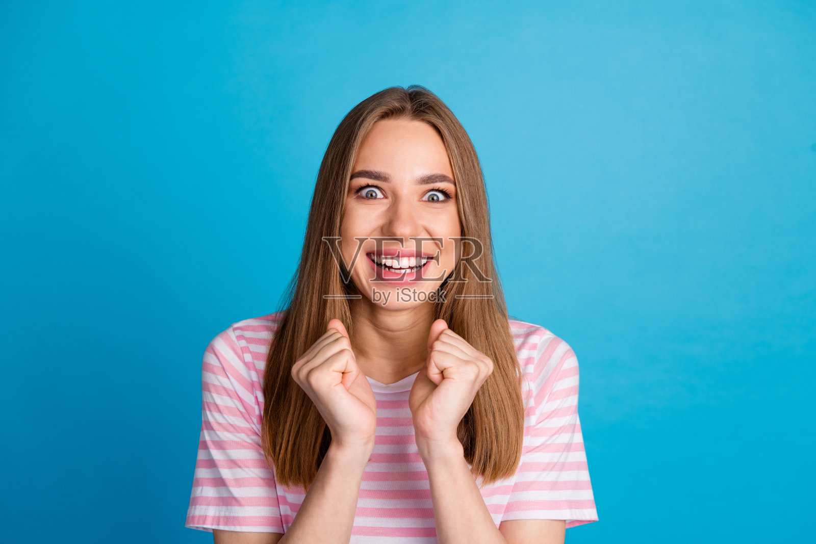 好心情可爱的女人穿着时髦的粉红色衣服孤立的蓝色背景的照片照片摄影图片