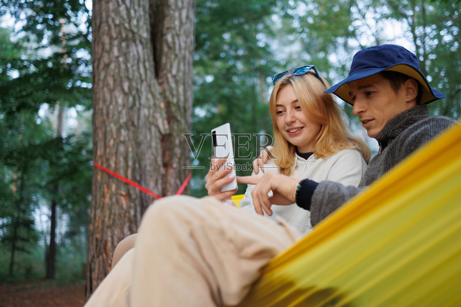 吊床上的幸福:沉迷于电话的夫妇照片摄影图片