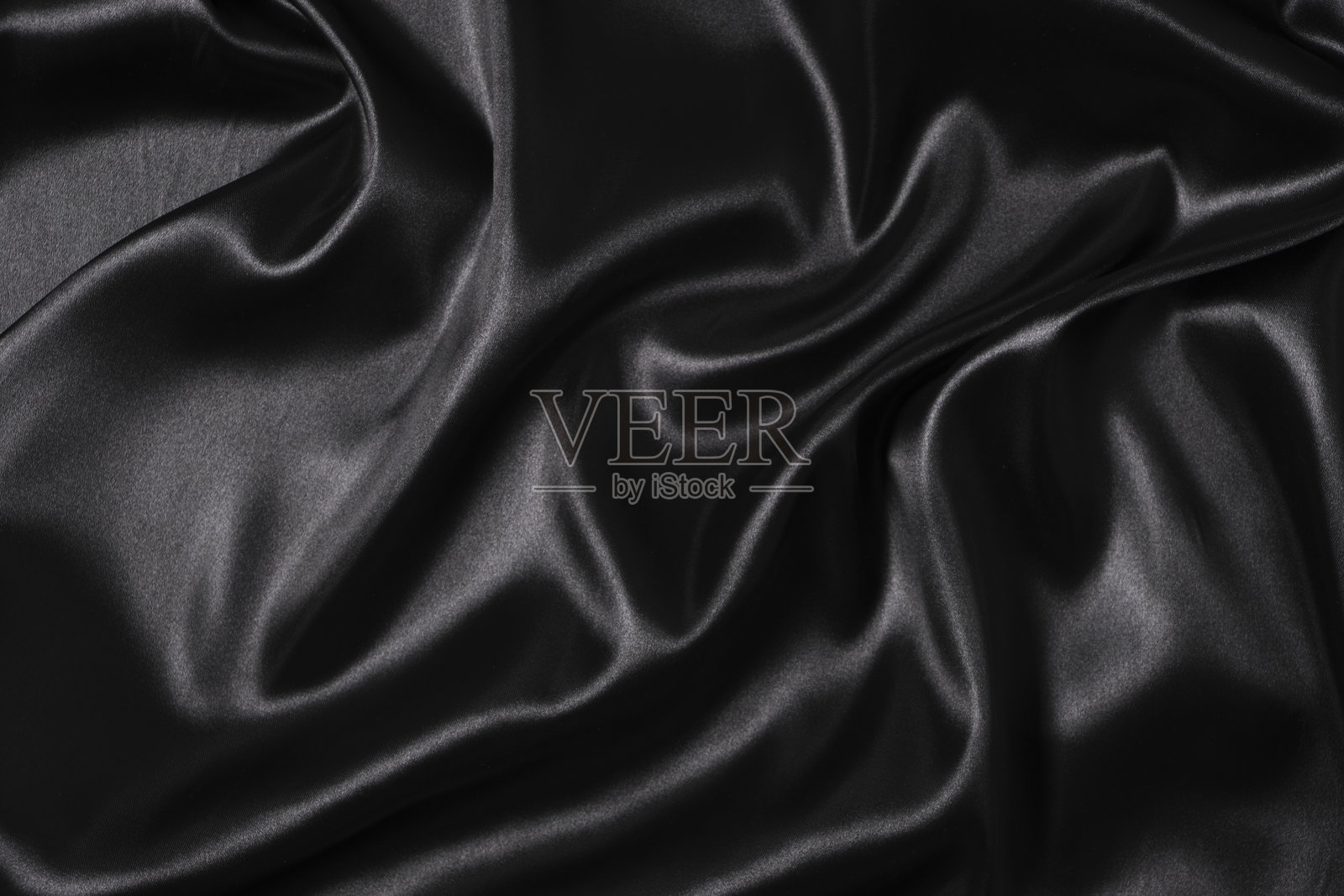 真丝织物，抽象波浪黑色缎面织物背景。照片摄影图片