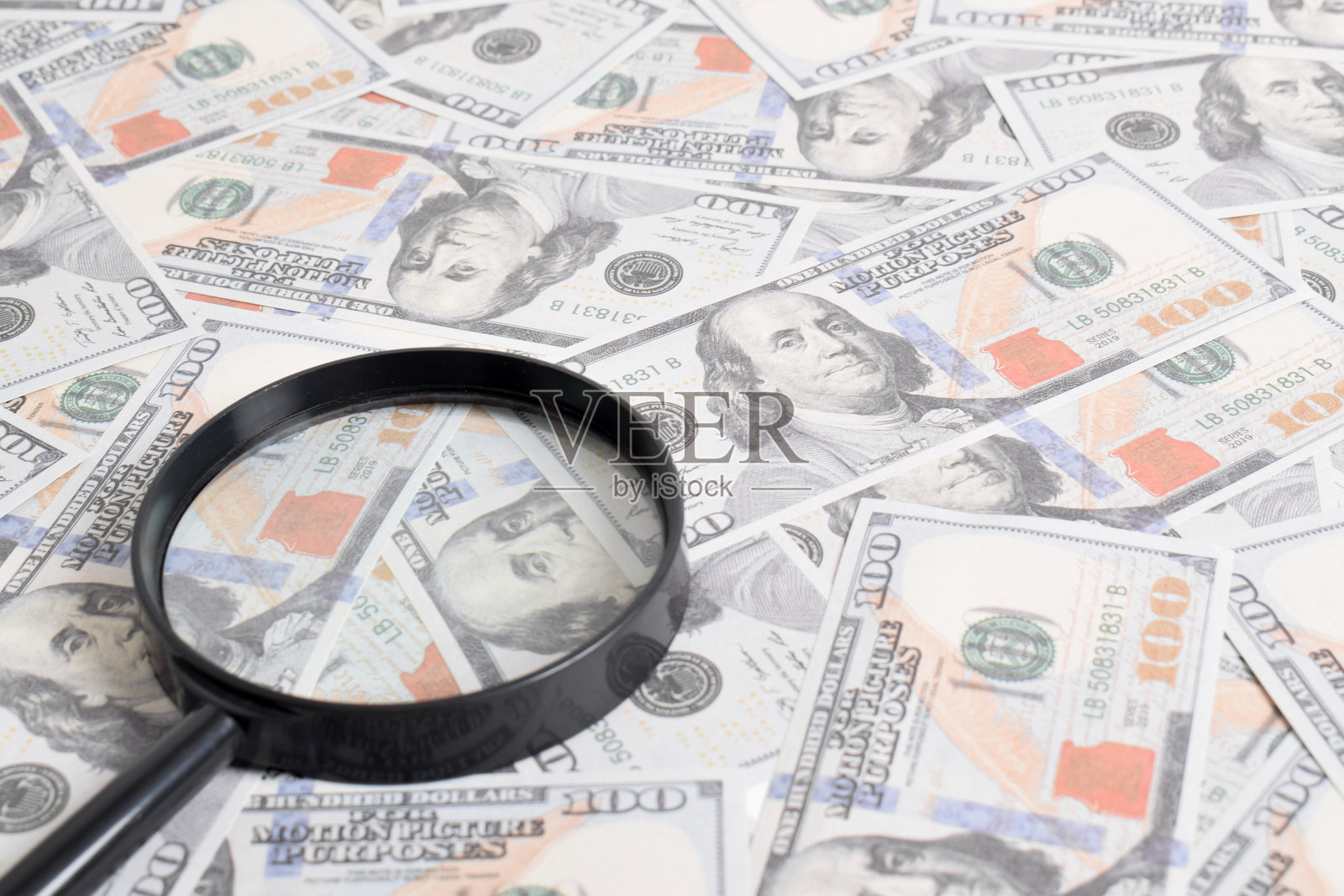 放大镜的背景是一捆美元照片摄影图片