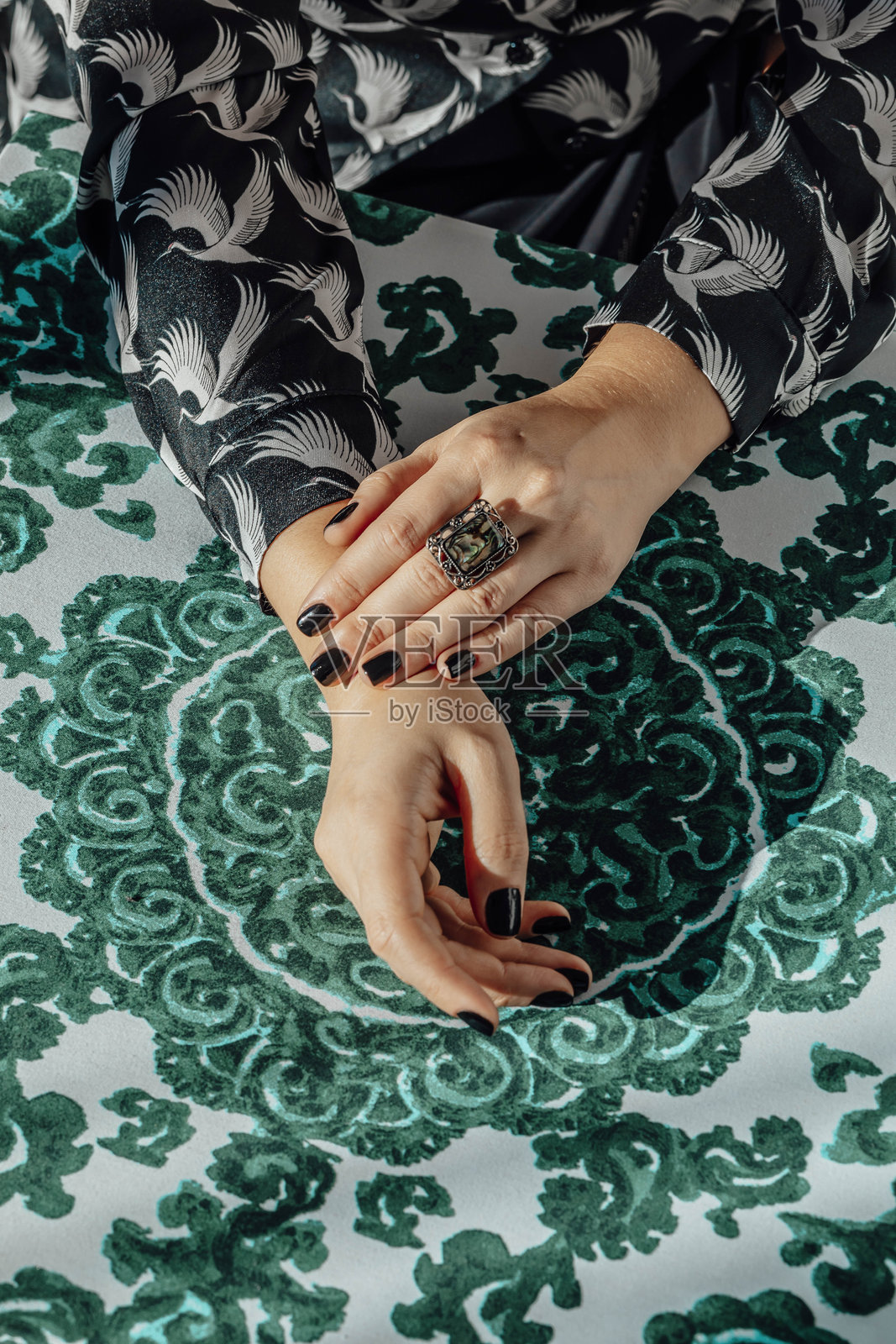 美丽的双手在传统的织物图案上搭配现代的配件，传统的织物图案搭配现代的配件照片摄影图片