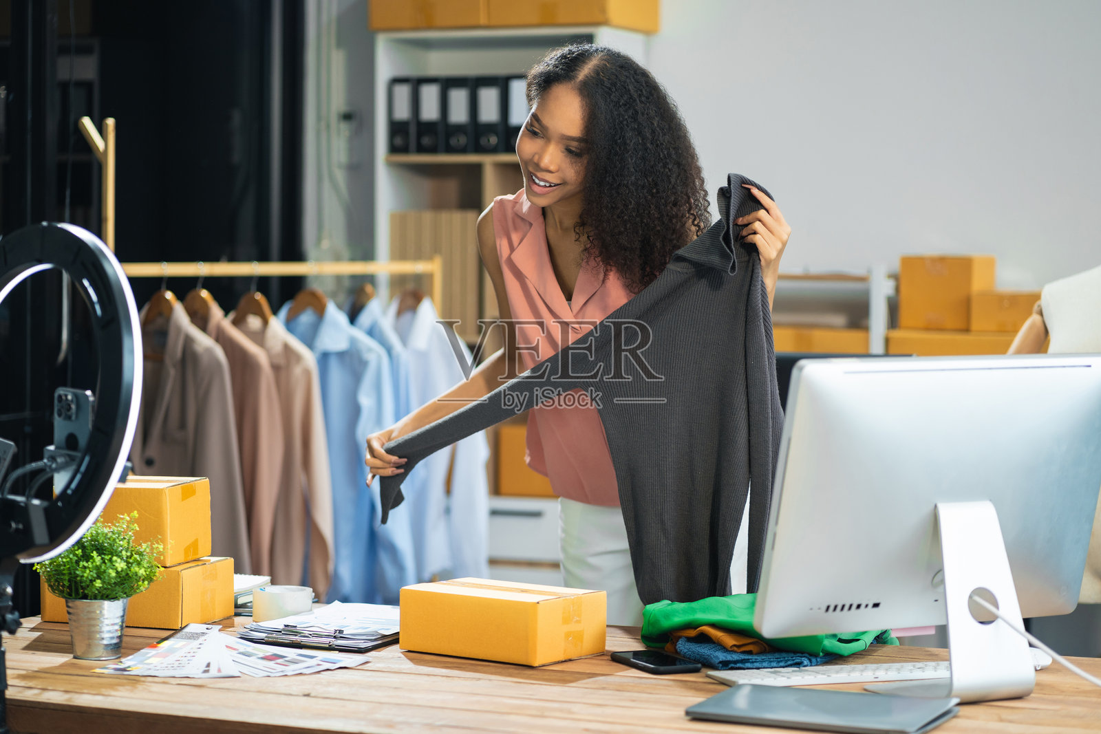 视频博主和设计师，中小企业零售店主微笑着享受销售节目现场销售在线屏幕智能手机和笔记本电脑在家工作。照片摄影图片