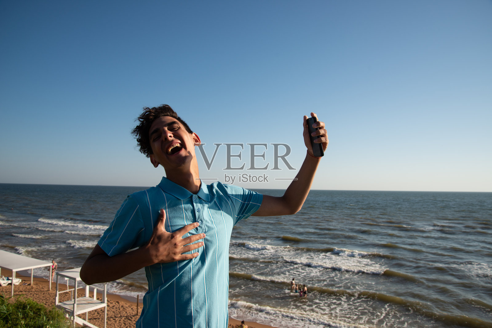 一个年轻英俊的小伙子走在沙滩上。照片摄影图片