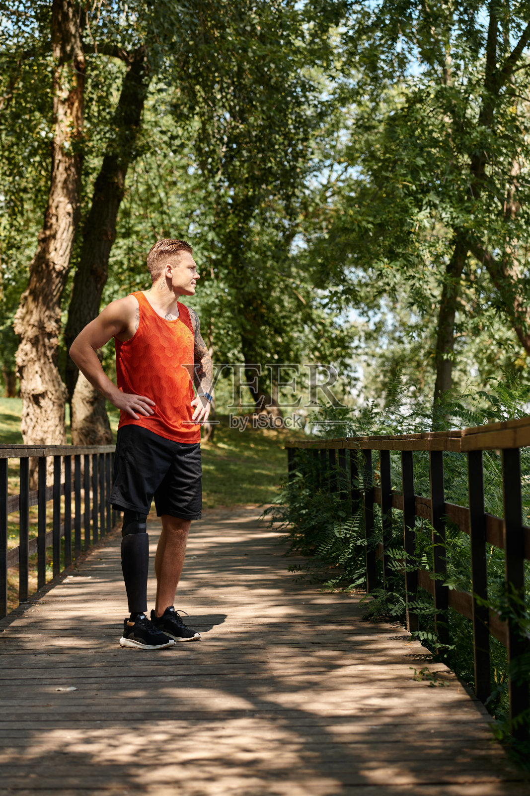 一个戴着假腿的年轻人在一个宁静的绿色公园里健身照片摄影图片