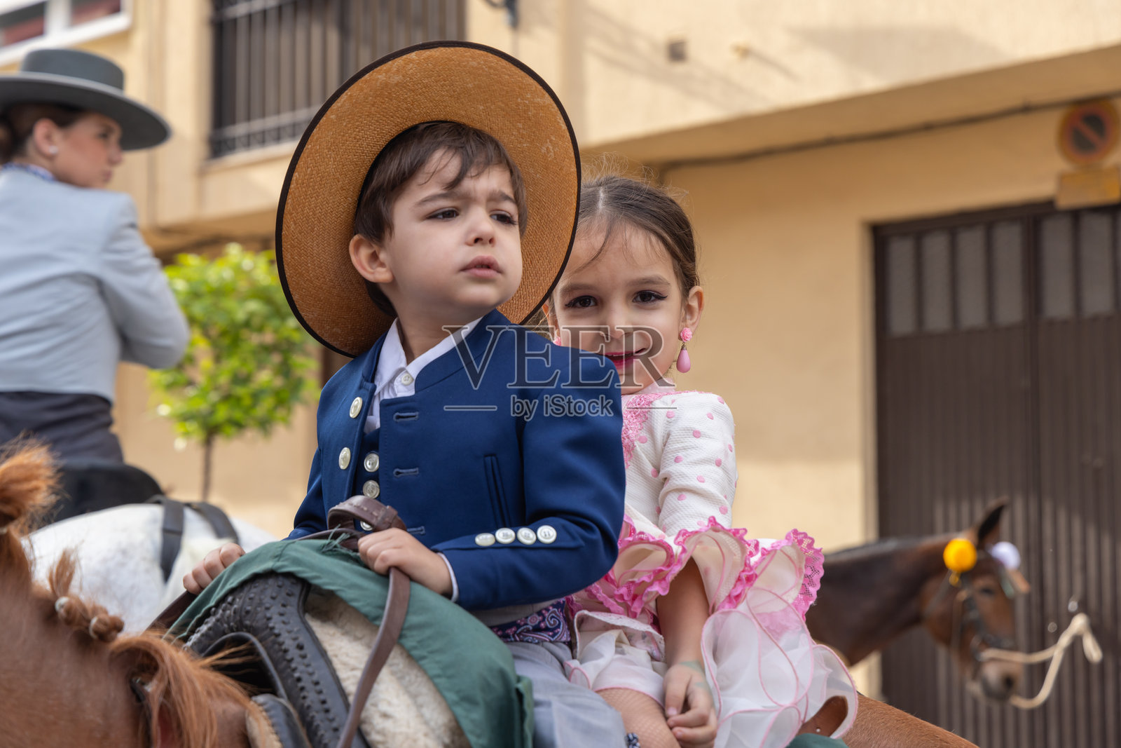 安杜哈尔的一个宗教节日中，男孩和女孩骑着马参加游行。照片摄影图片