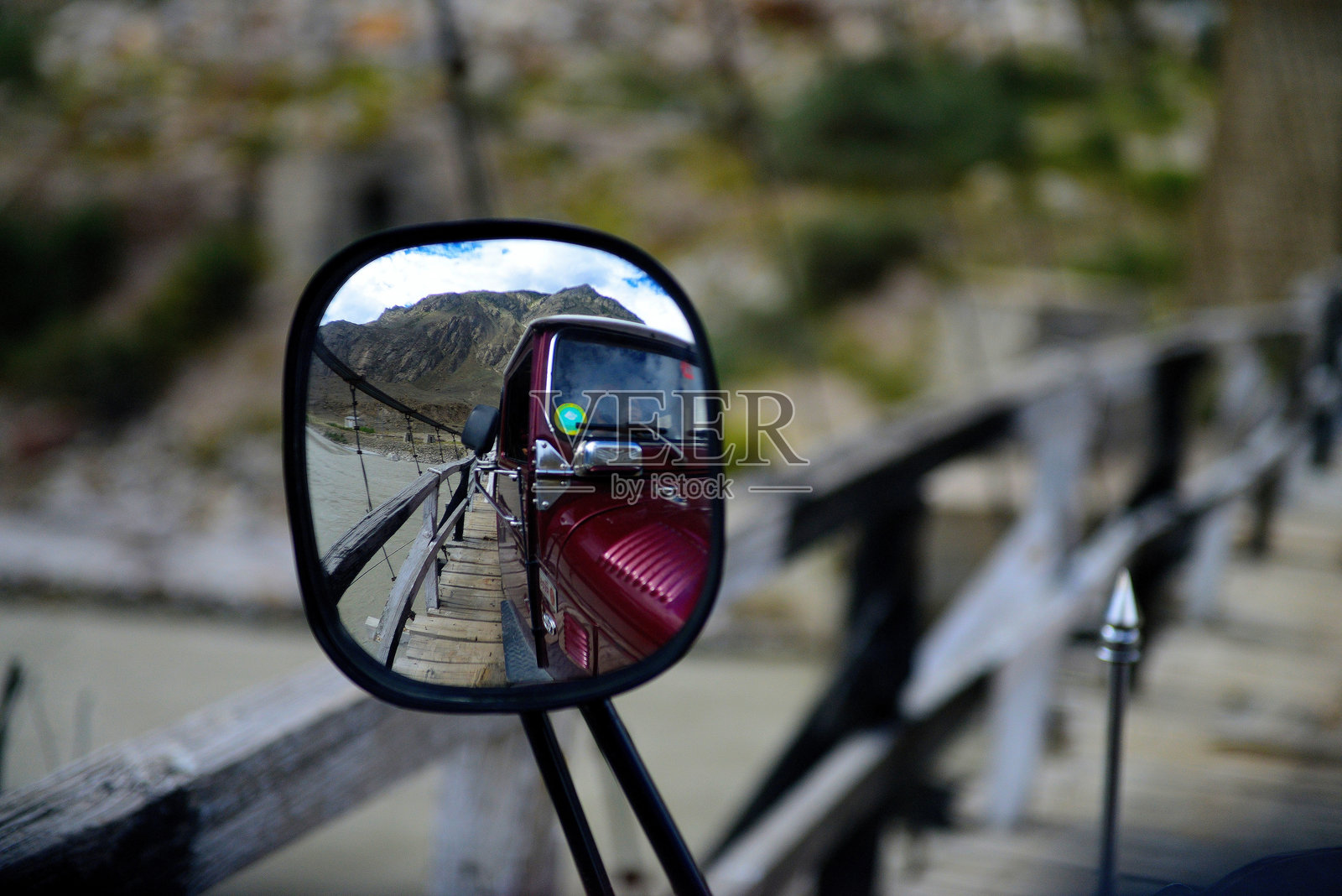 一辆汽车通过一座木制吊桥时的后视镜特写照片摄影图片