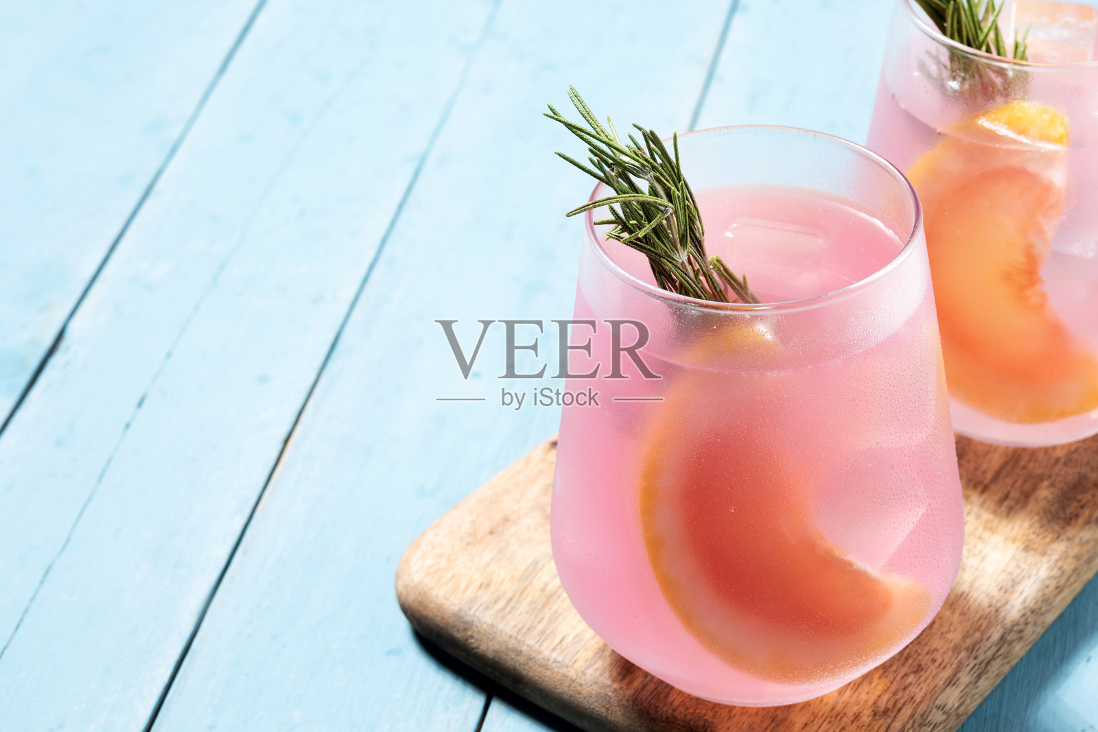 蓝色木桌上的葡萄柚鸡尾酒照片摄影图片