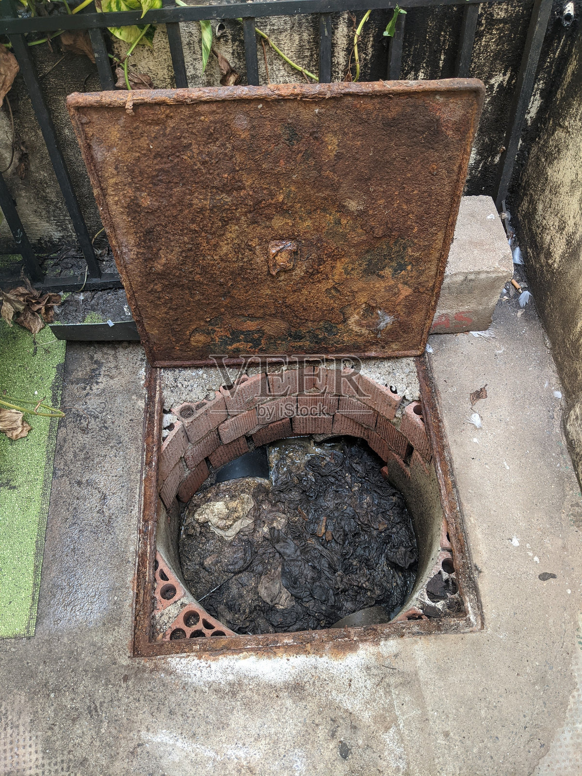 建筑人孔被湿巾和污垢堵塞照片摄影图片